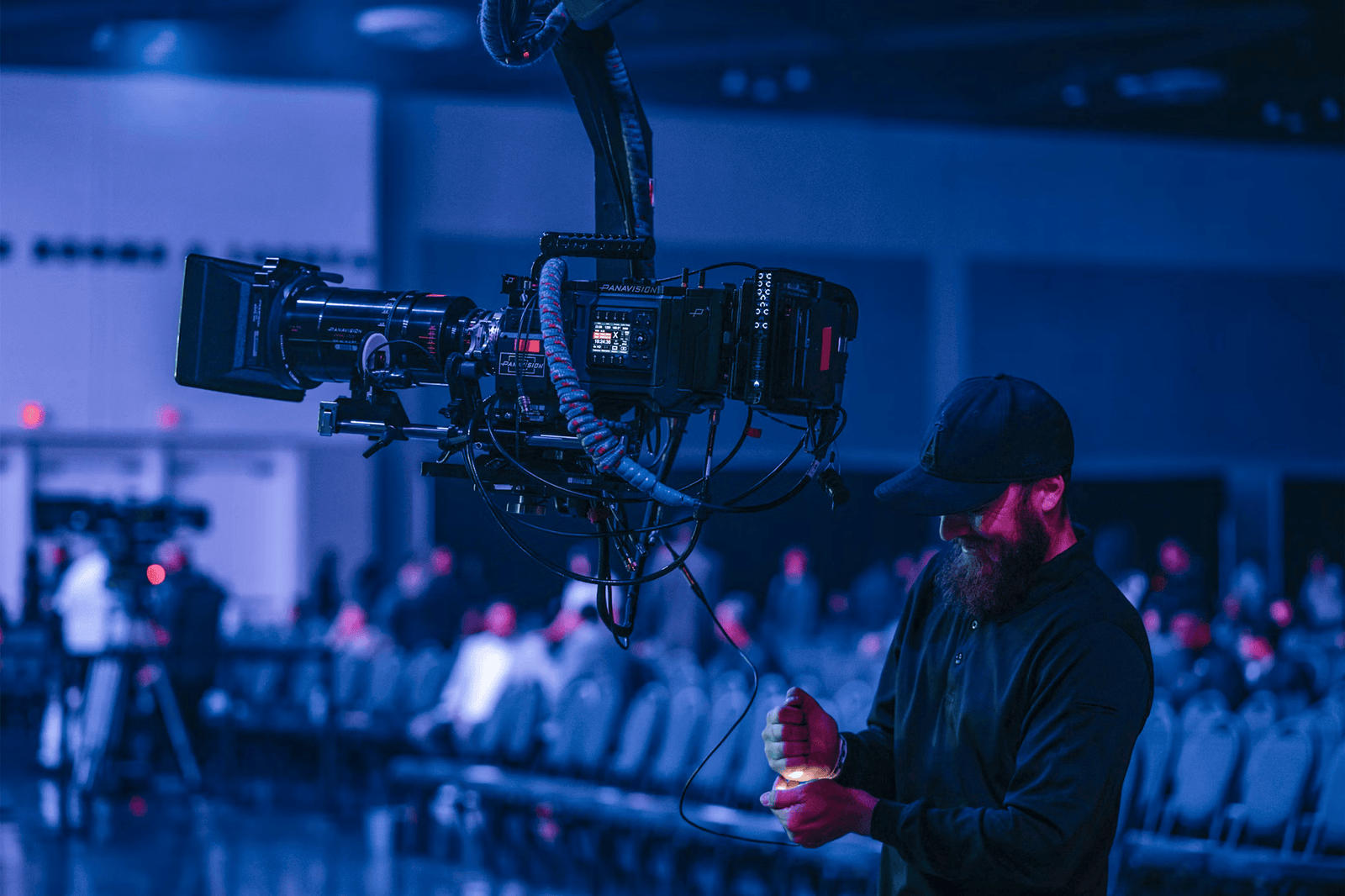 Videógrafo a operar uma câmara durante um evento empresarial.